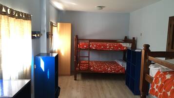 Habitación con literas, un escritorio y un armario.