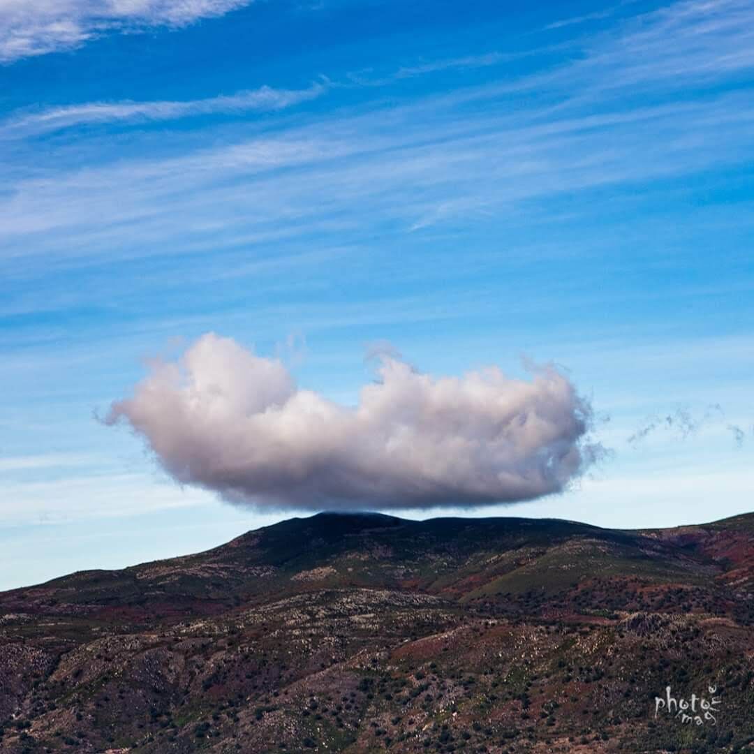 A mountainous landscape with a prominent cloud formation.