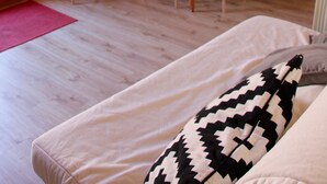 A compact room with a dining table, chairs, a sofa, and a window with blinds. - Hostel El Lago Caceres (Cuacos de Yuste)