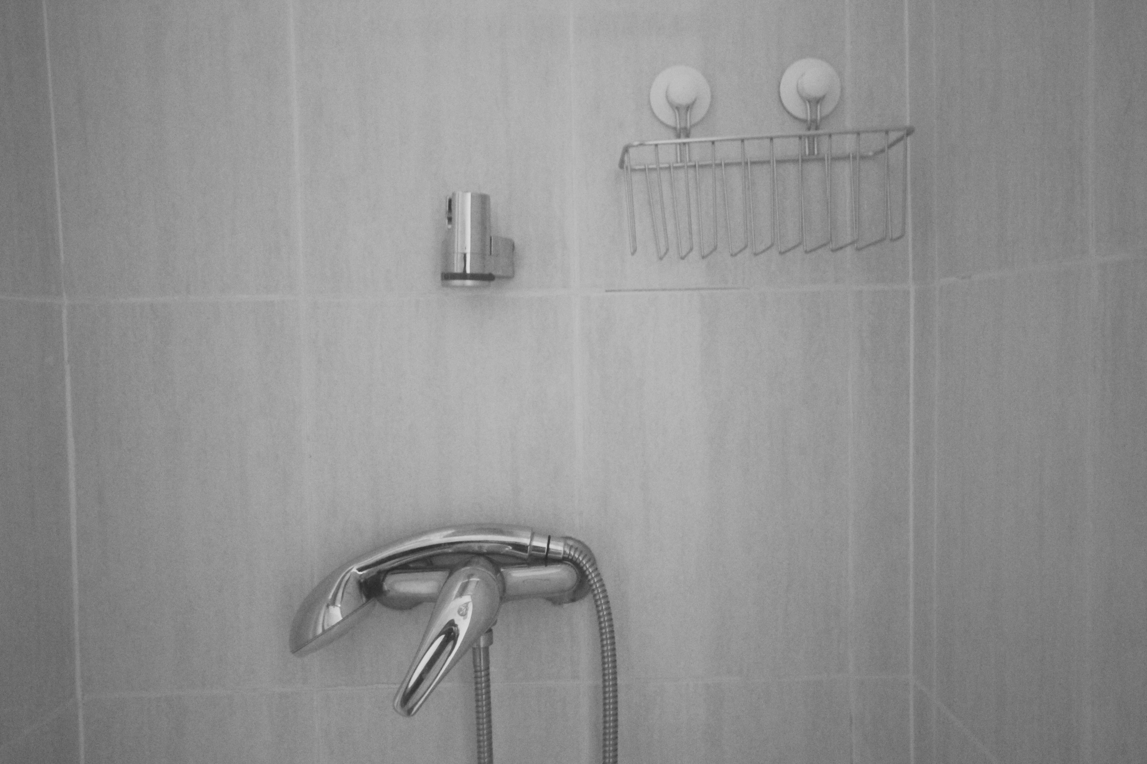 Une salle de bain équipée d’une douche, d’un porte-serviettes et d’un distributeur de savon.
