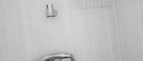 A bathroom with a shower, a faucet, and a soap dish.