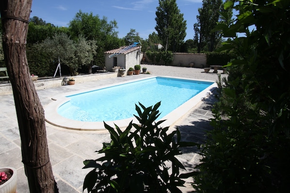Una piscina al aire libre de temporada, sillones reclinables de piscina