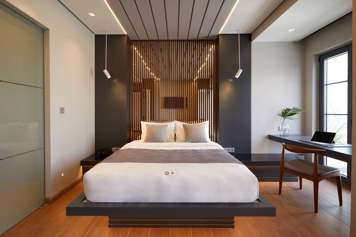 Ein modernes Schlafzimmer mit Bett, Nachttisch und Schreibtisch mit Stuhl.