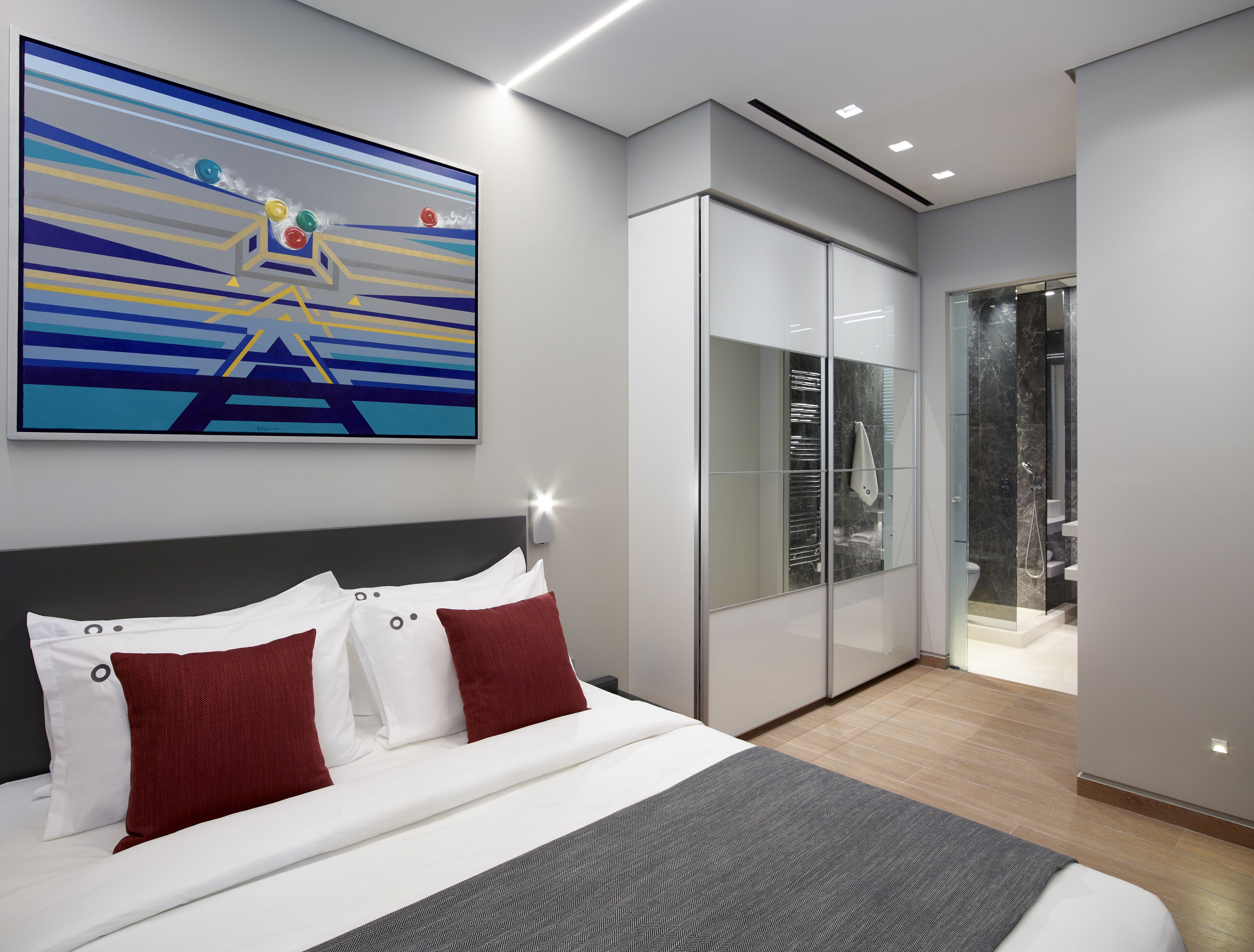 Un dormitorio moderno con una cama grande, un armario y una zona de ducha.