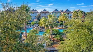 Un resort con varias construcciones, piscina y abundante vegetación.