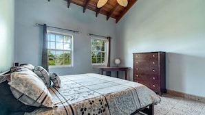 A bedroom with a bed, a dresser, two windows, and a view of greenery outside. - Ocean Front Condo - just steps from the beach!  Gold Standard Approved (San Pedro)