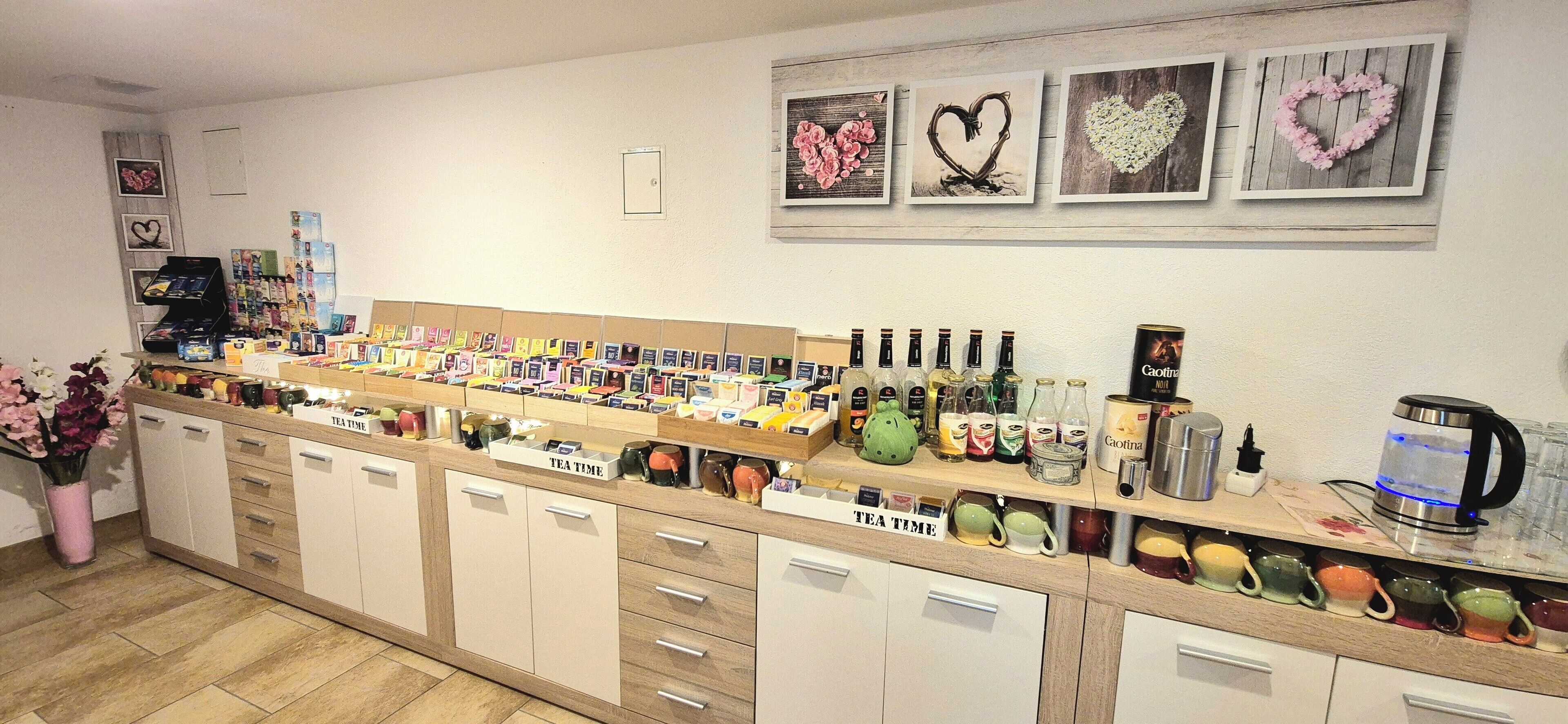 Una tienda de té con una variedad de productos, una máquina de café y decoraciones con forma de corazón en la pared.