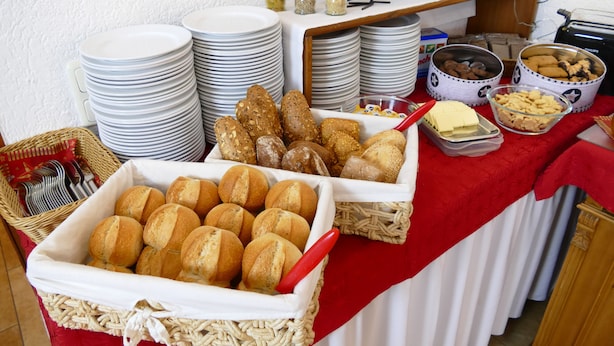 Una mesa de buffet con diversos alimentos, como pan, galletas y salsas.