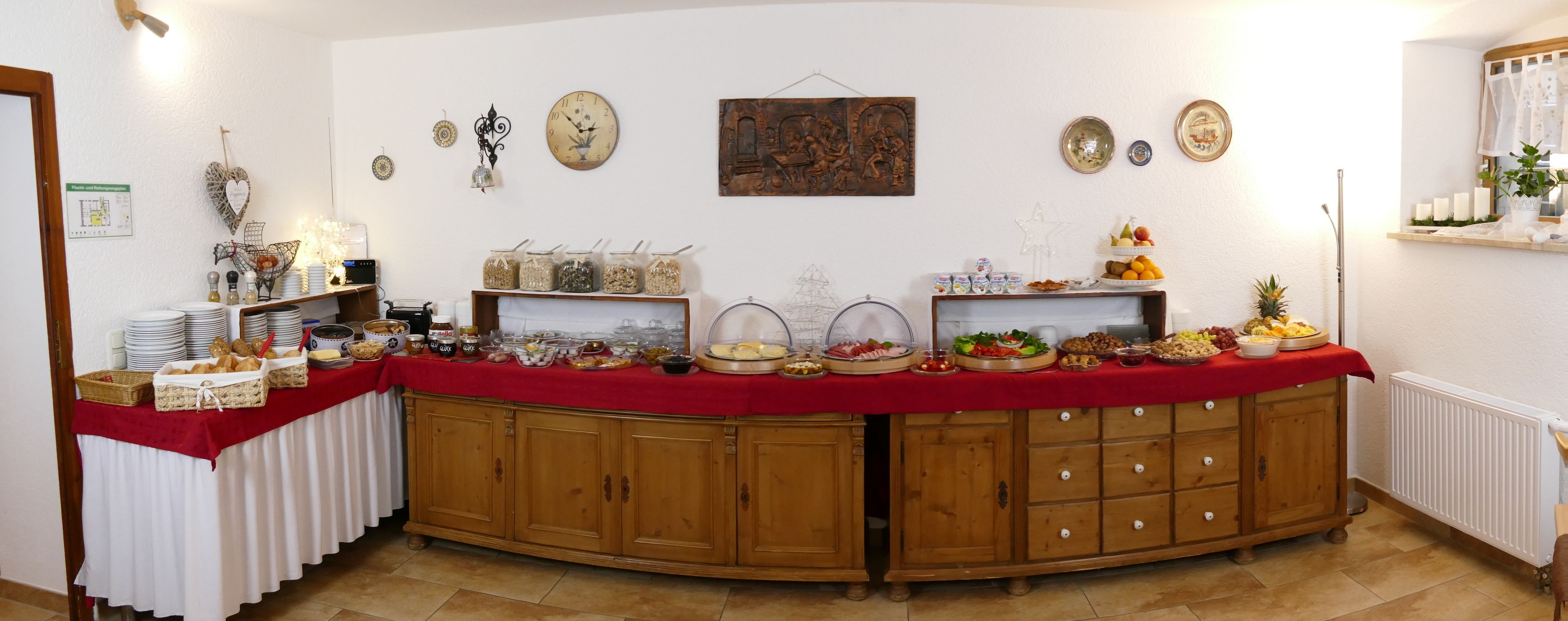 A buffet setup with various food items and decorative elements on a wooden cabinet.