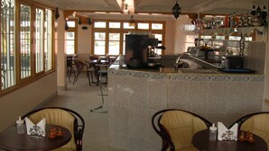 A restaurant with a bar area, seating, and a coffee machine. - Résidence Touristique Koutoubienne (Marrakech)
