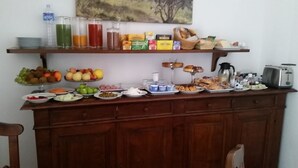 A breakfast buffet with various fruits, pastries, and beverages. - Palazzo Raho (Cefalù)