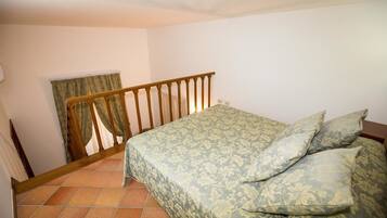 Une chambre à coucher avec un lit, une rambarde en bois et une fenêtre avec des rideaux.