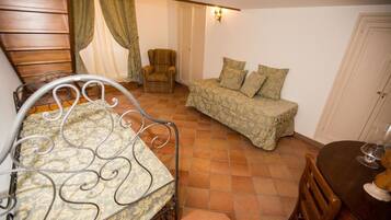 A cozy room with a bed, a sofa, a chair, and a small table.