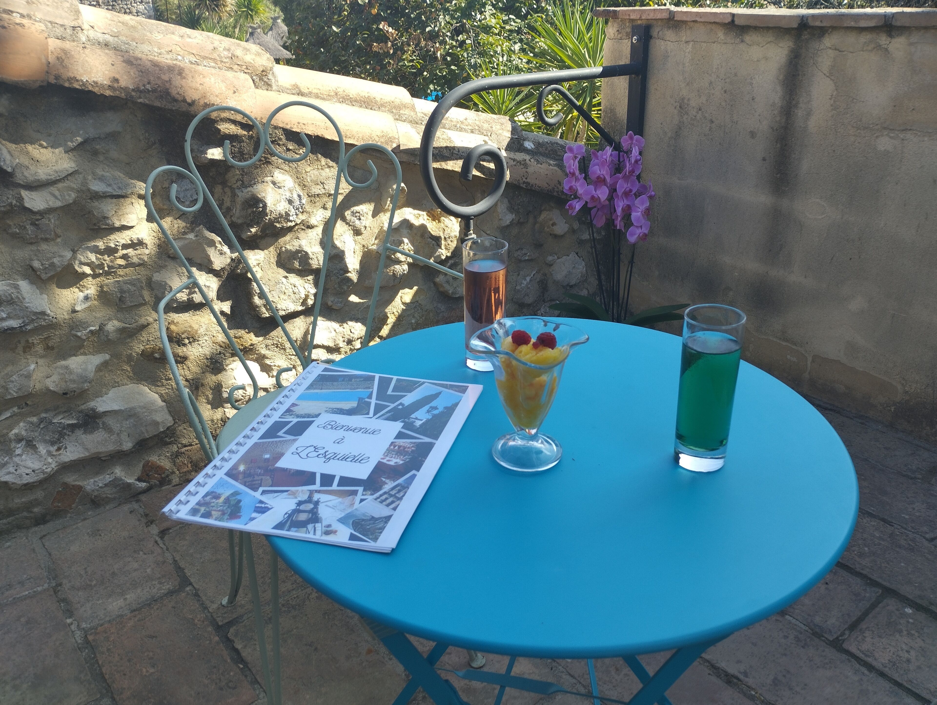 Una mesa con un menú, un postre y dos bebidas.