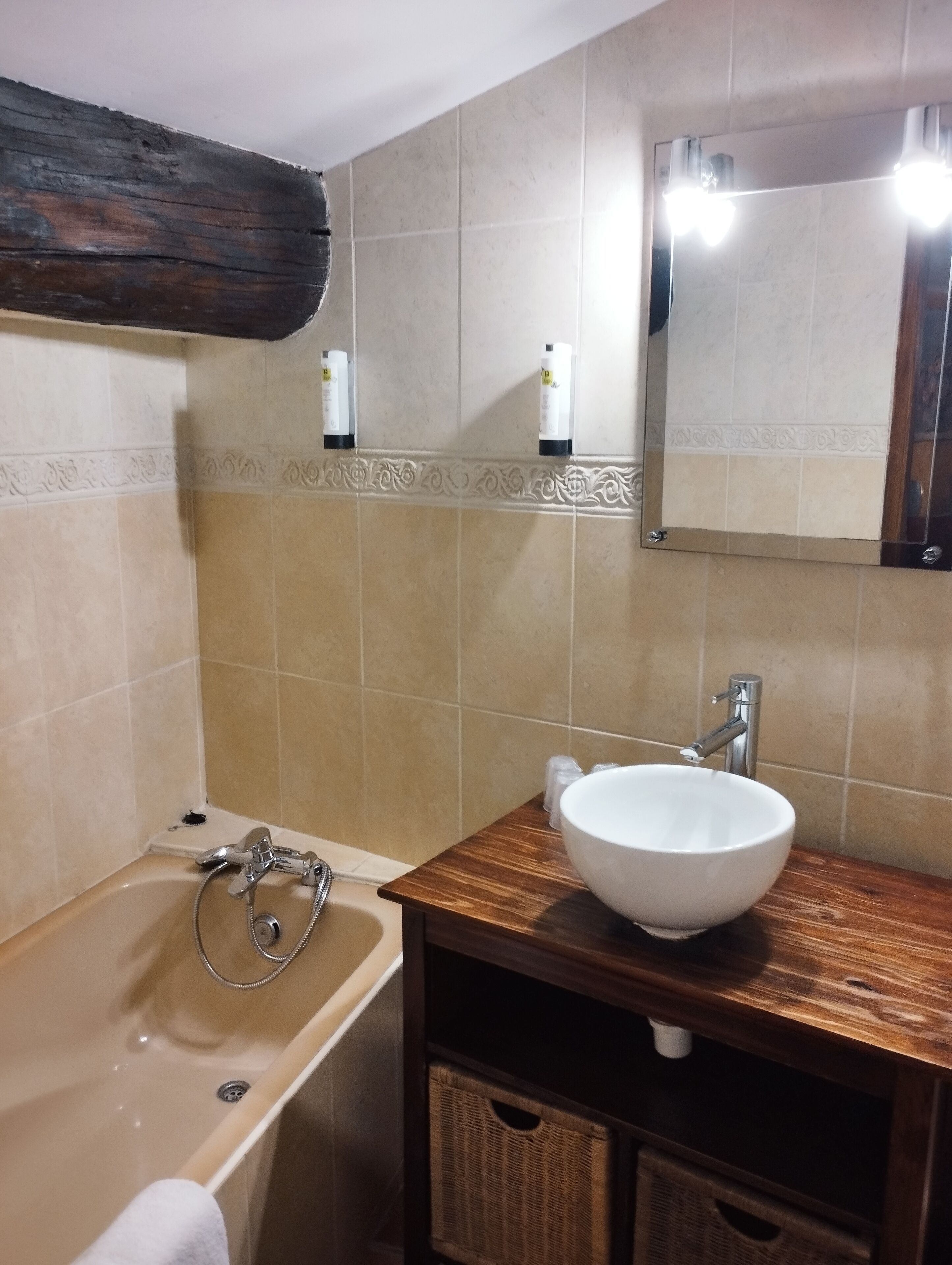 A bathroom with a bathtub, a sink, and a mirror.