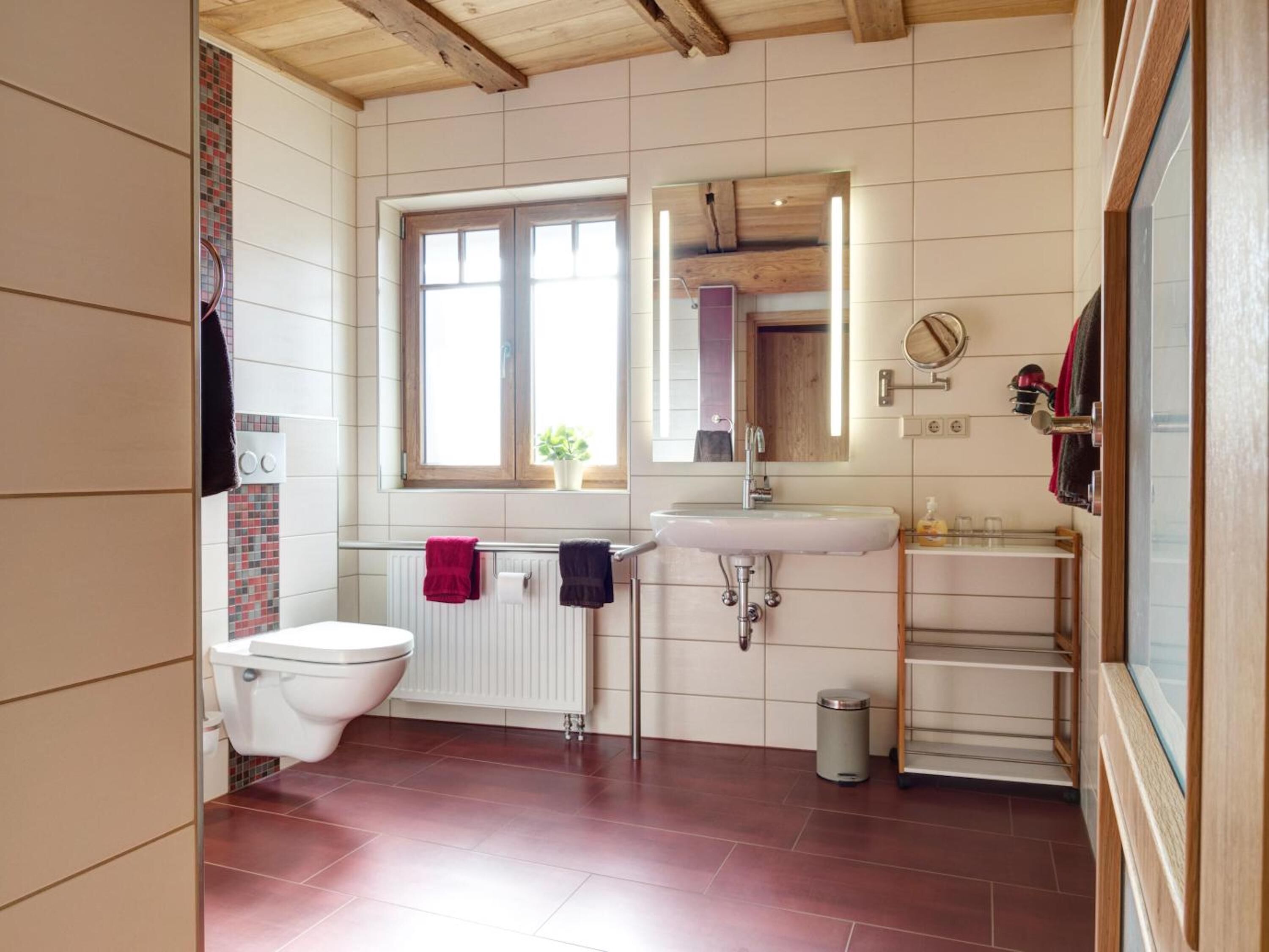 Ein Badezimmer mit Toilette, Waschbecken und Fenster.