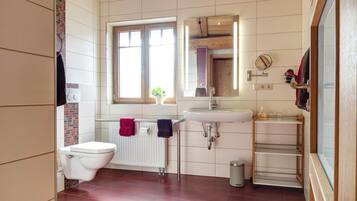Ein Badezimmer mit Toilette, Waschbecken und Fenster.