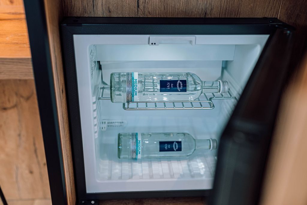 A refrigerator with two bottles of medium-sized water and a bottle of H2O2.