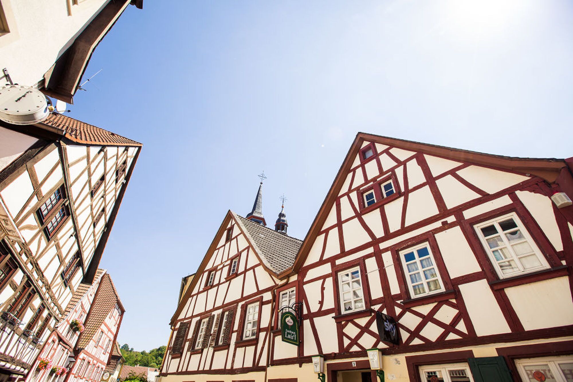 A traditional half-timbered building with a visible chimney and a sign indicating a restaurant.