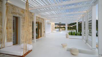 Relax in a serene lounge area with a swing seat and scenic views of the surrounding landscape.