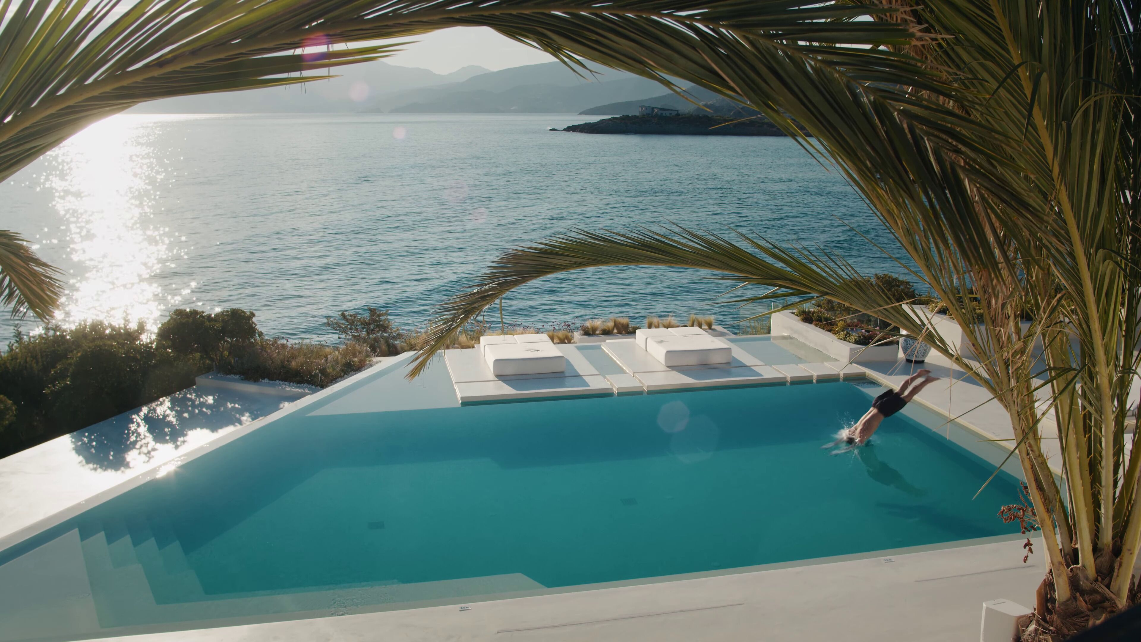 Una piscina con vistas al mar y a las montañas.