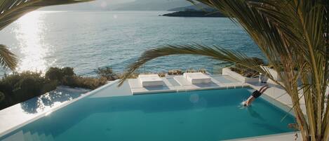 Una piscina con vistas al mar y a las montañas.
