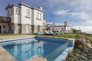 Una piscina al aire libre, sillones reclinables de piscina