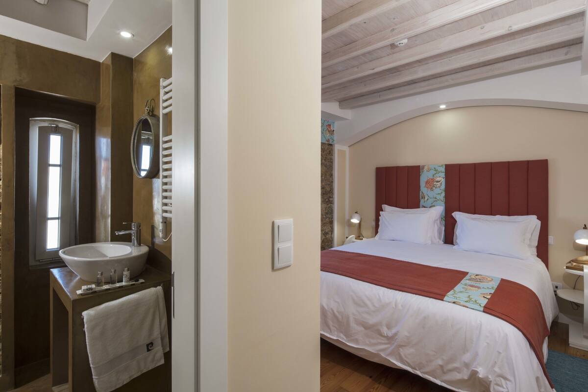A bedroom with a large bed, a bedside table, and a nightstand.