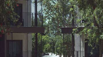 Un camino que lleva a un edificio moderno con balcones y un cielo despejado.