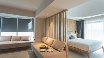 Una habitación de hotel moderna con sofá, cama y un separador de madera.