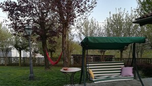 A patio area with a swing set, a table, and a hammock. - Villa Laura (Incisa Scapaccino)