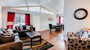 A spacious living room with a high ceiling, a dining area, and a large window providing natural light. - ★ Easy Check-in ★ By Downtown Littleton ★ Full Kitchen ★ (Littleton)