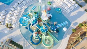 Relax and play in our vibrant water park area, featuring water slides and play structures surrounded by lounge chairs and umbrellas.