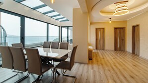 A modern conference room with a glass table and chairs, large windows, and a wooden floor. - Harmonia Colours (Budva)