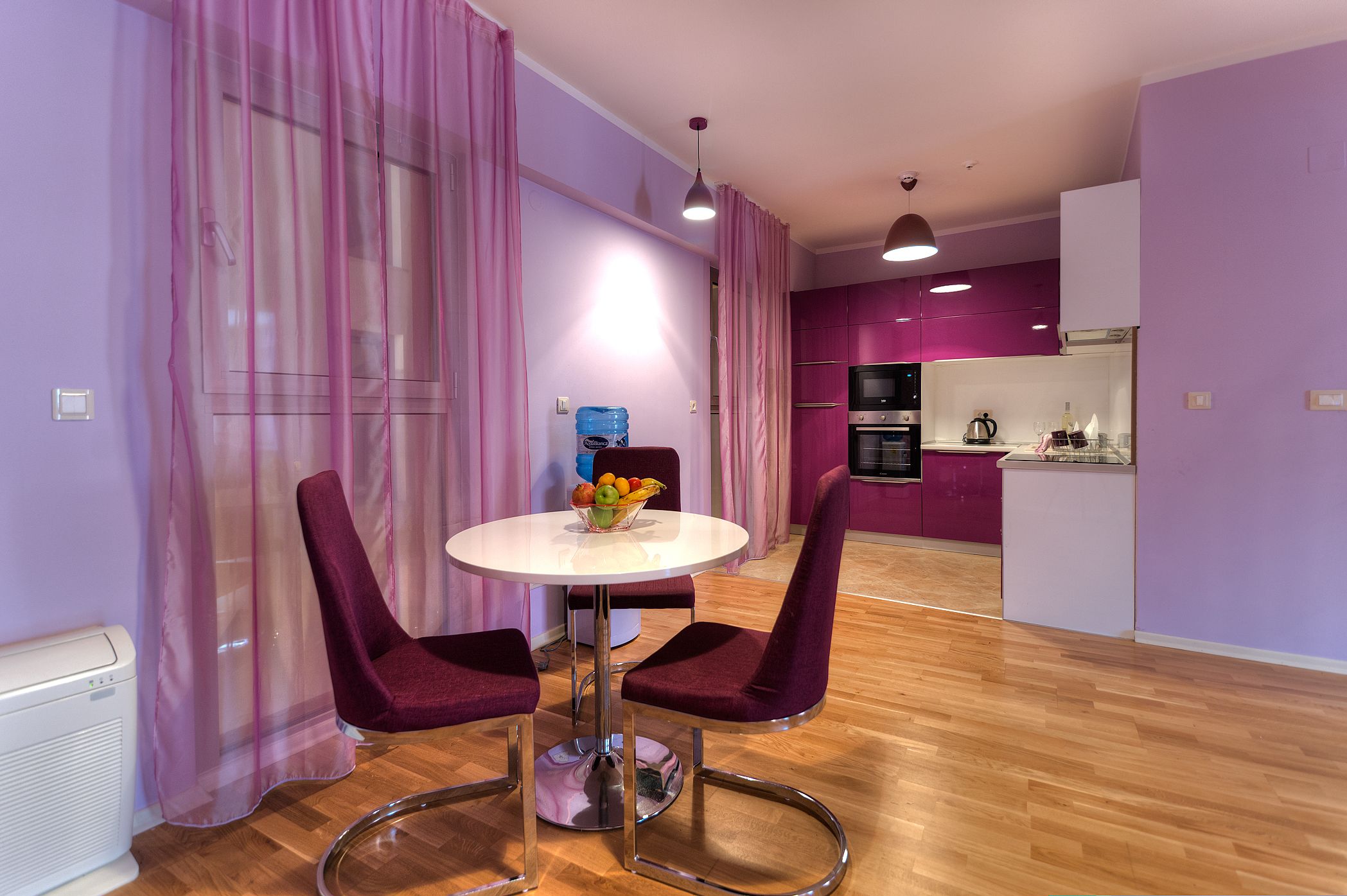 A modern kitchen with purple cabinets and stainless steel appliances.