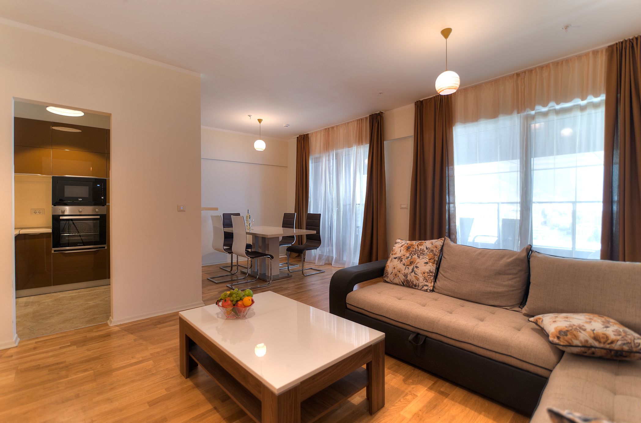 Una sala de estar moderna con un sofá, una mesa de centro y un comedor con una mesa y sillas.
