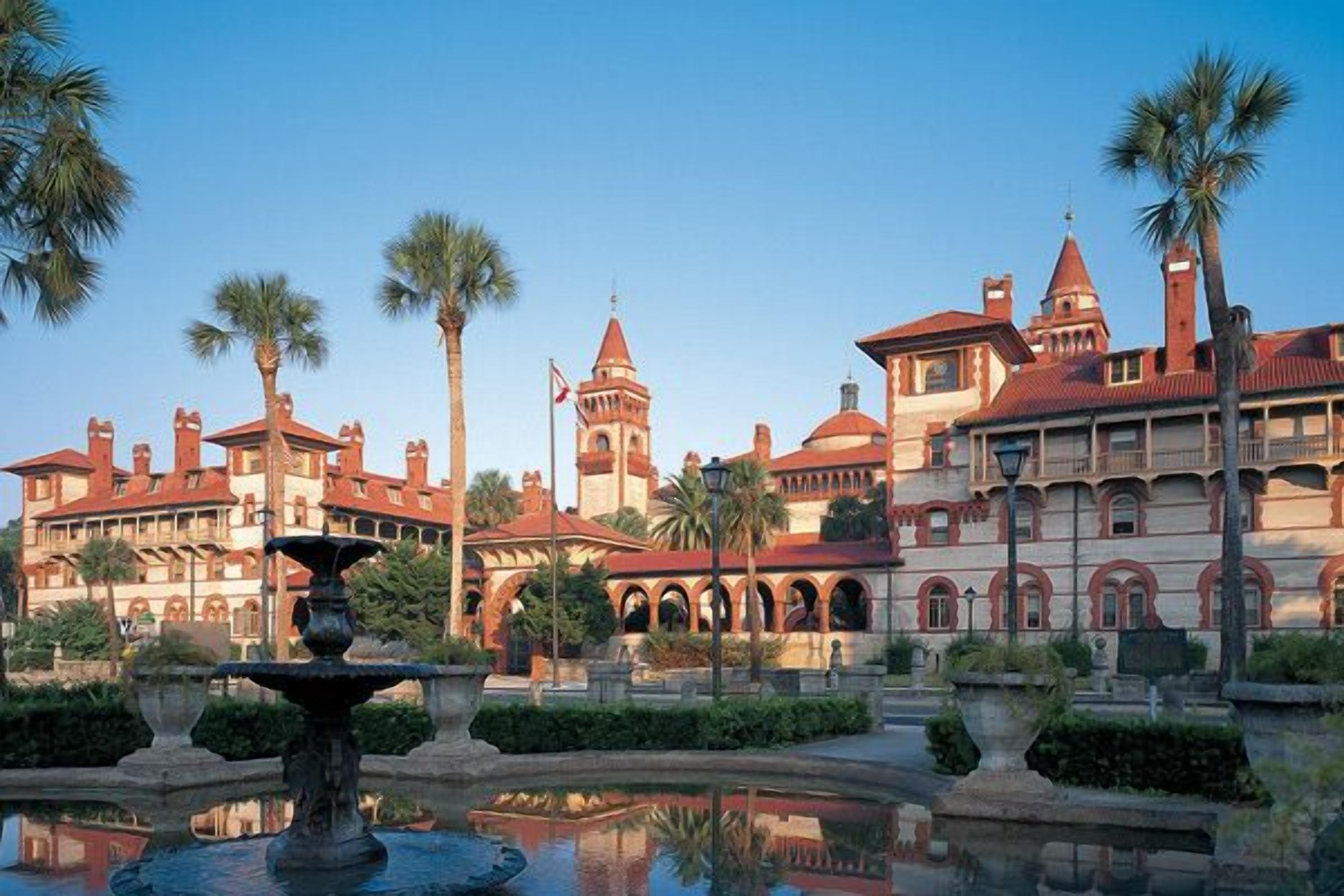 A historic building with arched walkways and a central fountain.