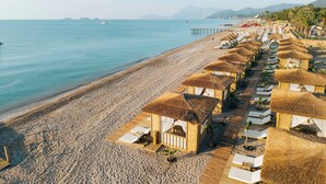 A beach resort with thatched-roof huts, wooden walkways, and a pier extending into the sea. - Pirates Beach Club - All Inclusive (Kemer)