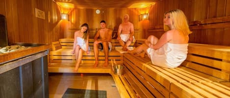 Uma sauna com bancos de madeira e uma bacia de metal.