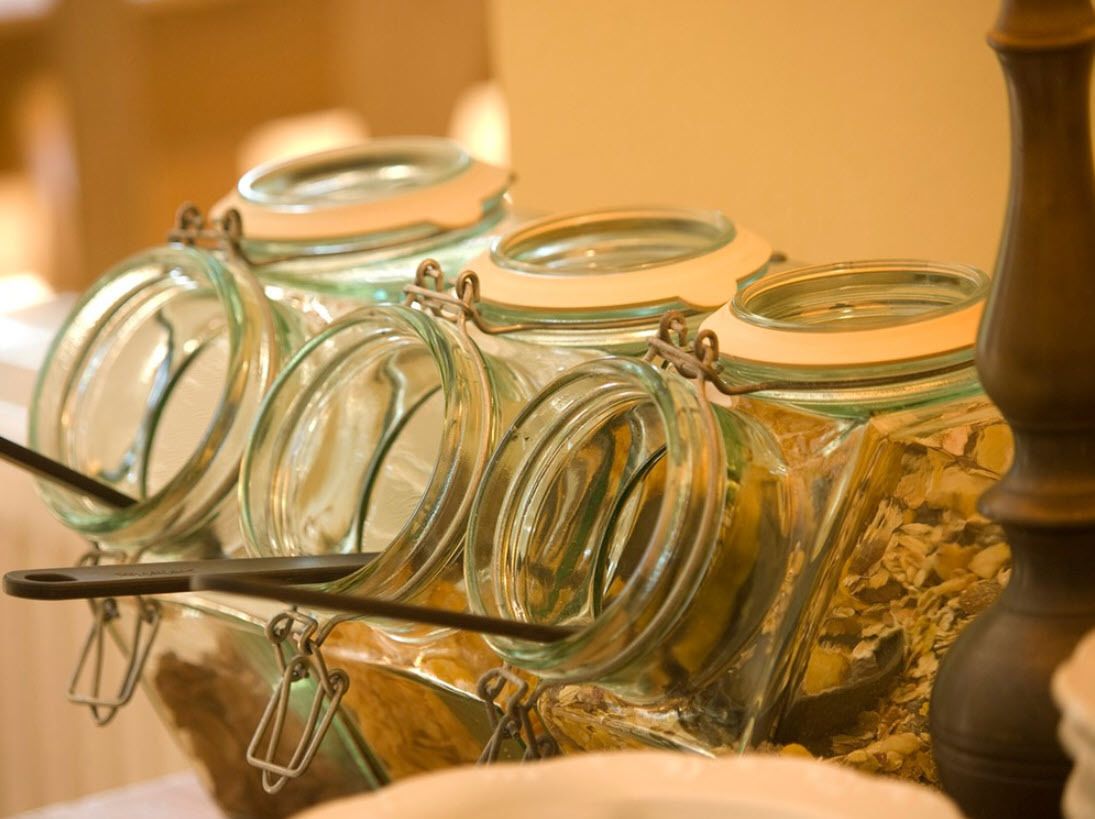 Glass jars with metal clasps, likely for food storage, arranged on a shelf.