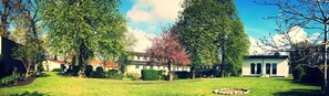 A residential area with a lawn, a circular garden, and two buildings with a traditional architectural style. - FerienResidenz MüritzPark (Röbel/Müritz)