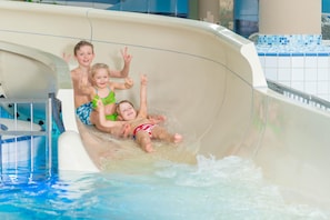 A water slide with three children sliding down. - FerienResidenz MüritzPark (Röbel/Müritz)