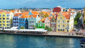 Un muelle con barcos frente a edificios de colores.