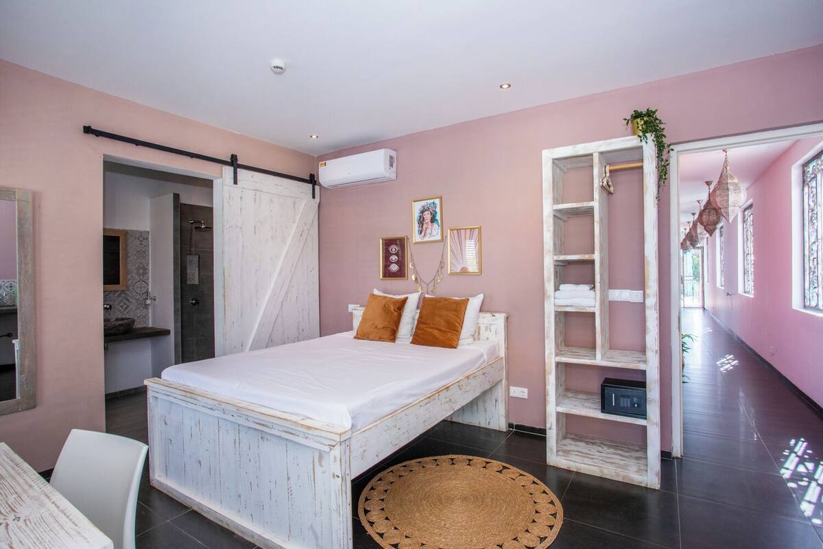 Une chambre à coucher comprenant un lit, une armoire, une salle de bain et un couloir.