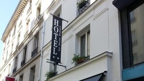 Fachada de hotel con un cartel llamativo que dice "HOTEL Le Saint Hubert".