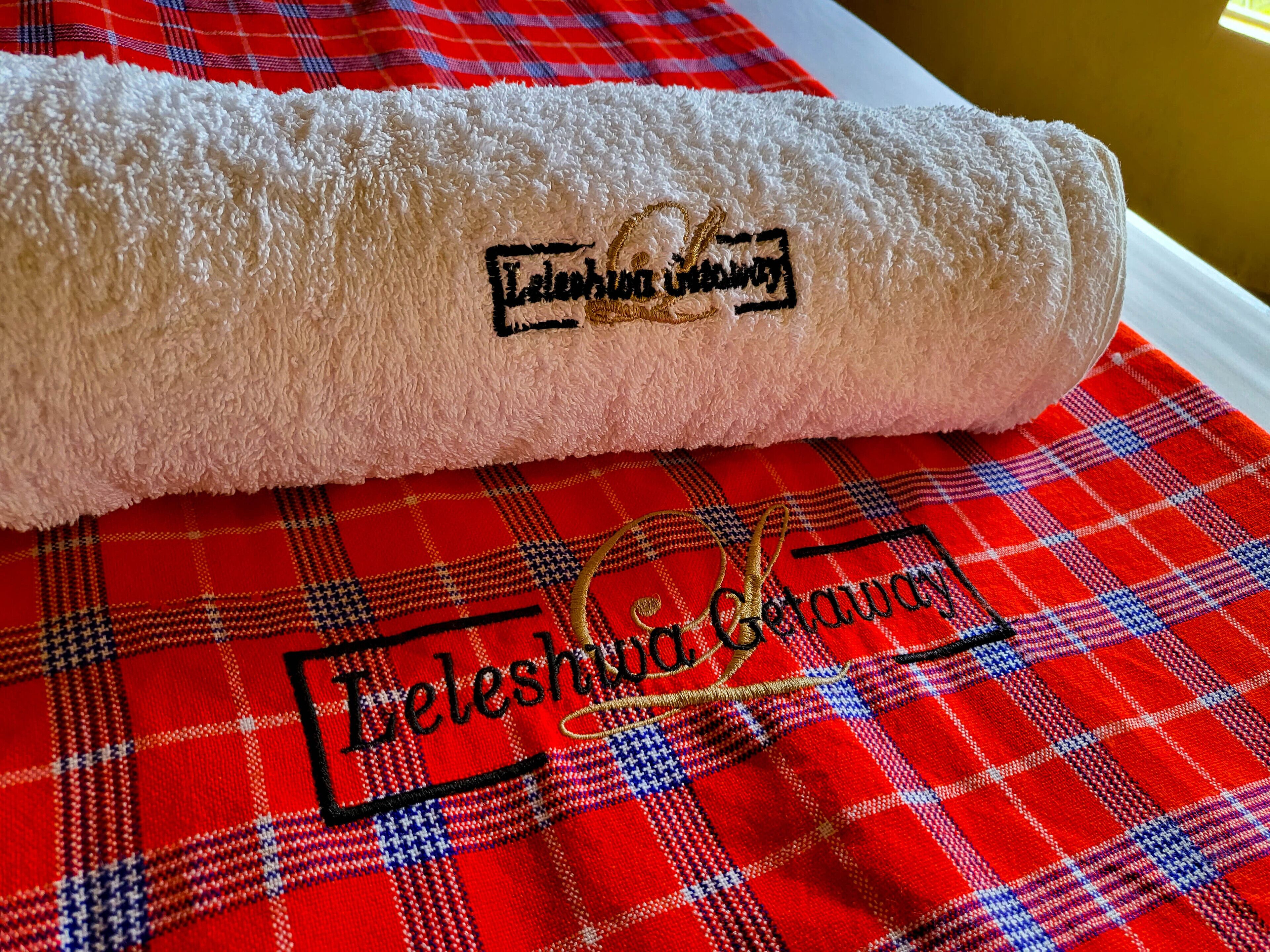 A rolled towel with embroidered text on a plaid fabric.