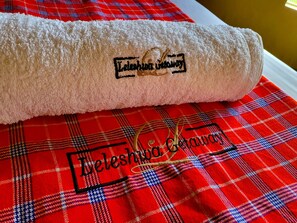 A rolled towel with embroidered text on a plaid fabric. - Leleshwa Getaway (Nairobi)