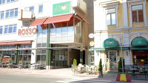 Straßenansicht mit einem Restaurant namens 'ROSSO' und einem weiteren namens 'ANTONI'.
