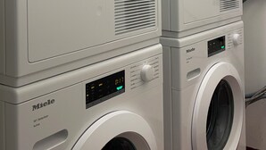 Eine Reihe weißer Miele Waschmaschinen mit digitalen Anzeigen und Bedienelementen.