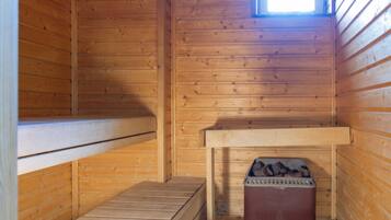 Une cabine de sauna en bois, dotée de bancs et d’une banquette.